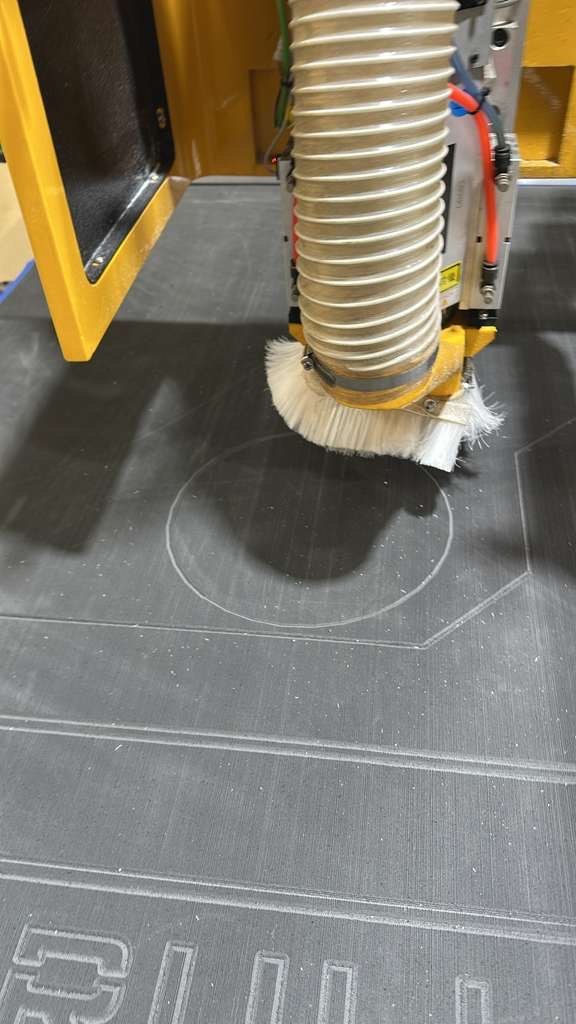 CNC router spindle and dust brush cutting into material