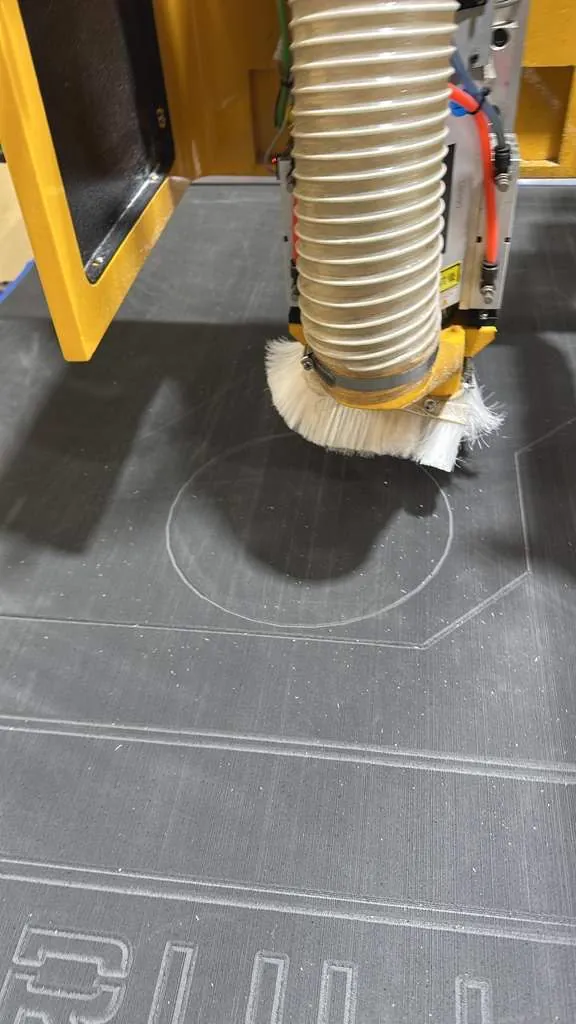 CNC router spindle and dust brush cutting into material