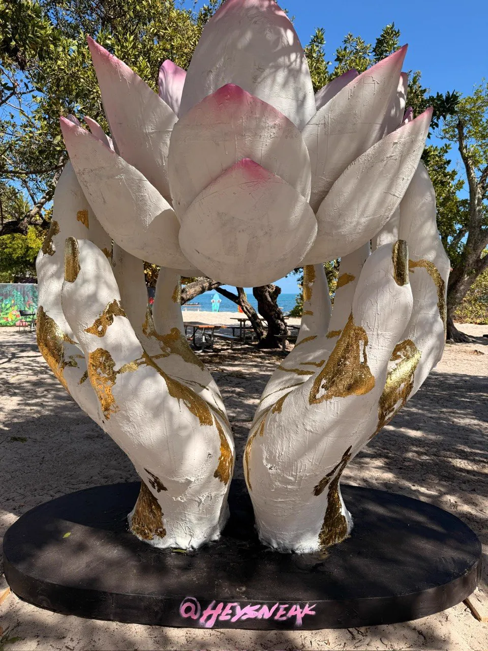 Large 3D printed sculpture of hands holding a lotus flower