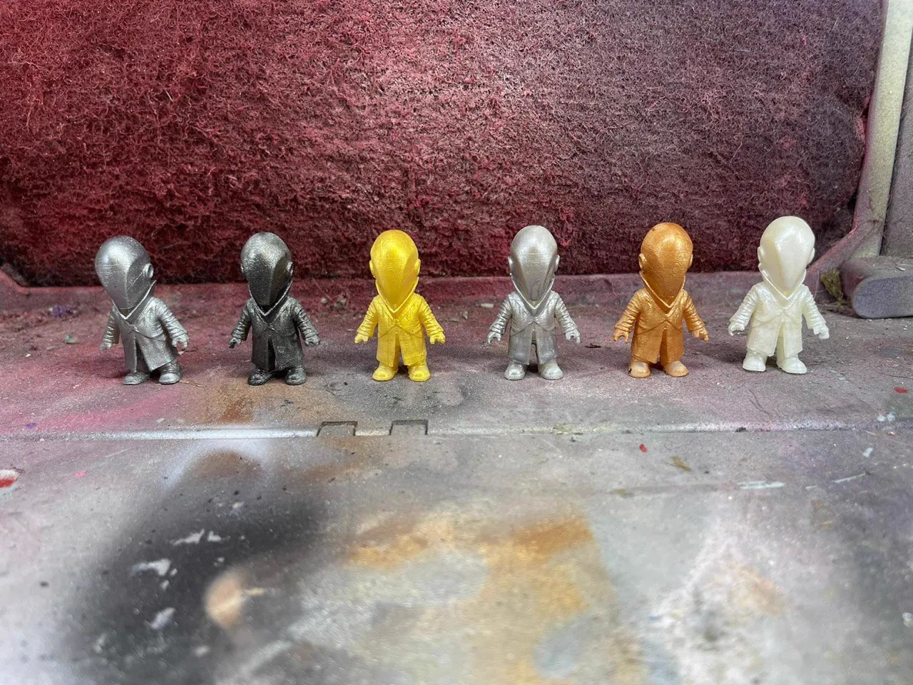 Set of six small hooded figurines finished in metallic gold, silver and bronze