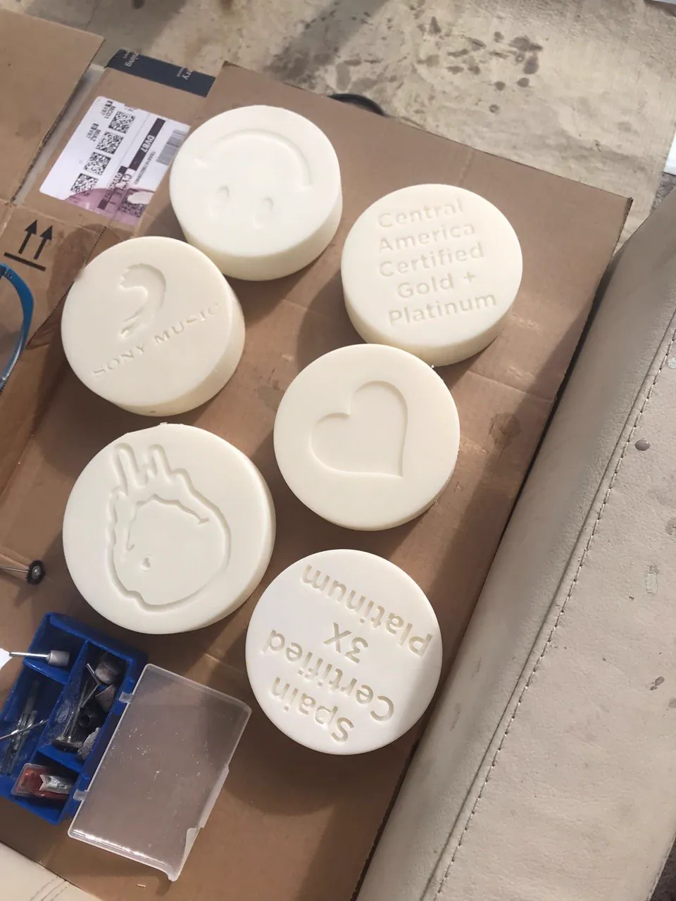 Five white resin embossing dies including a record label logo