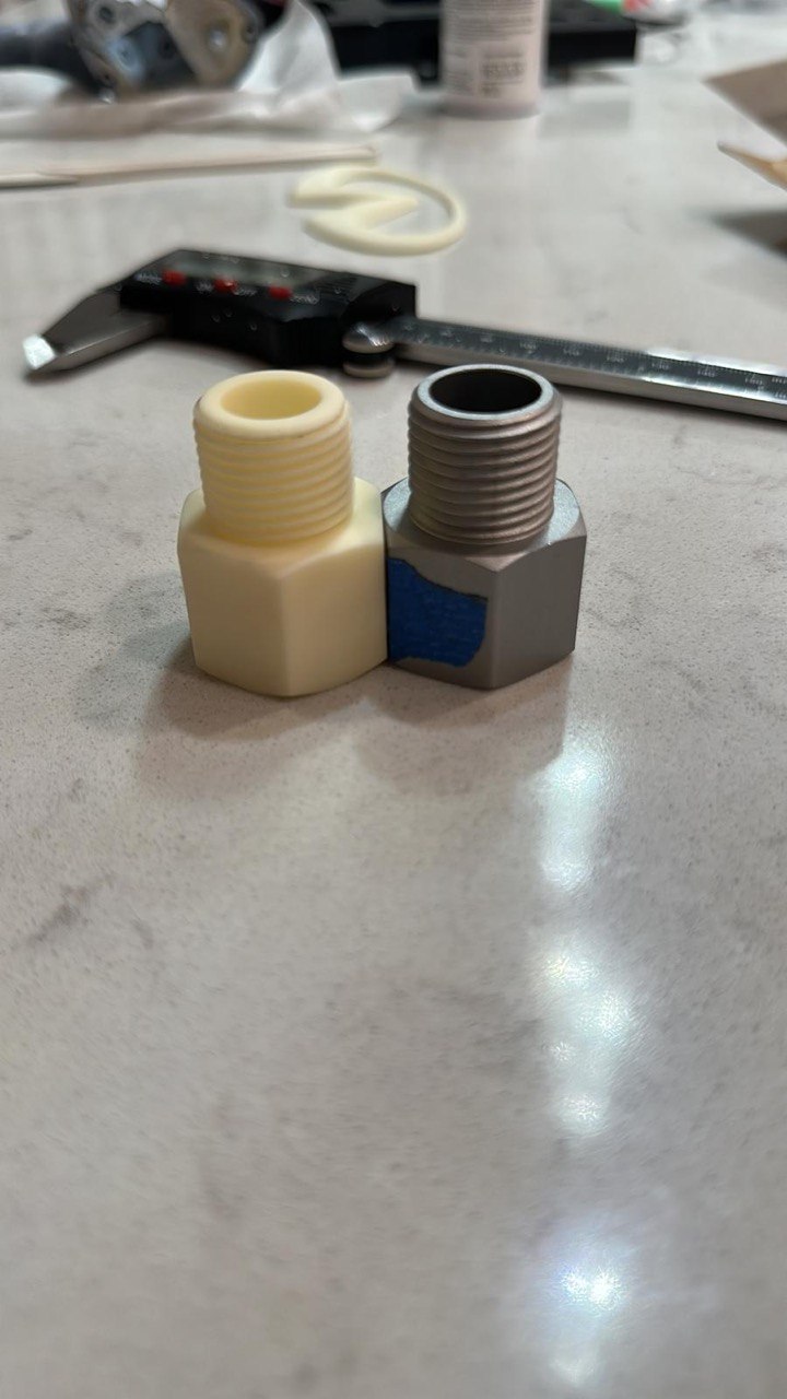 Digital caliper measuring an original metal fitting beside its 3D printed replica