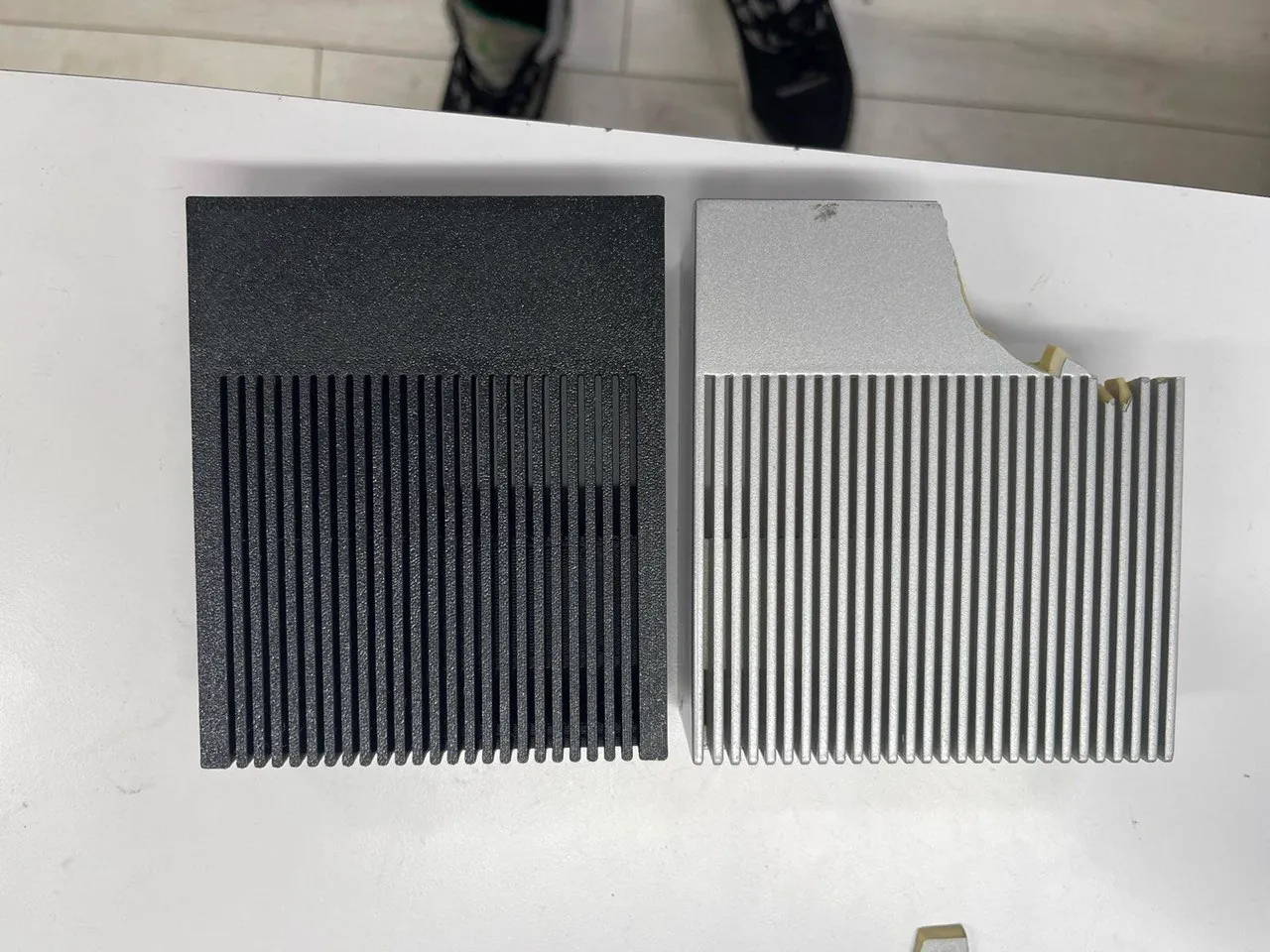 3D printed finned heatsink shroud next to the aluminum original