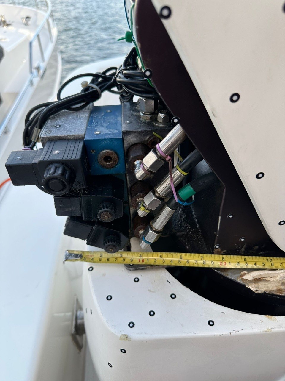 Tape measure spanning a boat hydraulic valve compartment